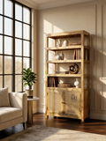 Wooden bookshelf with decorative items in a room with large windows and a sofa.