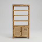 Wooden bookshelf with a rattan door on a gray background