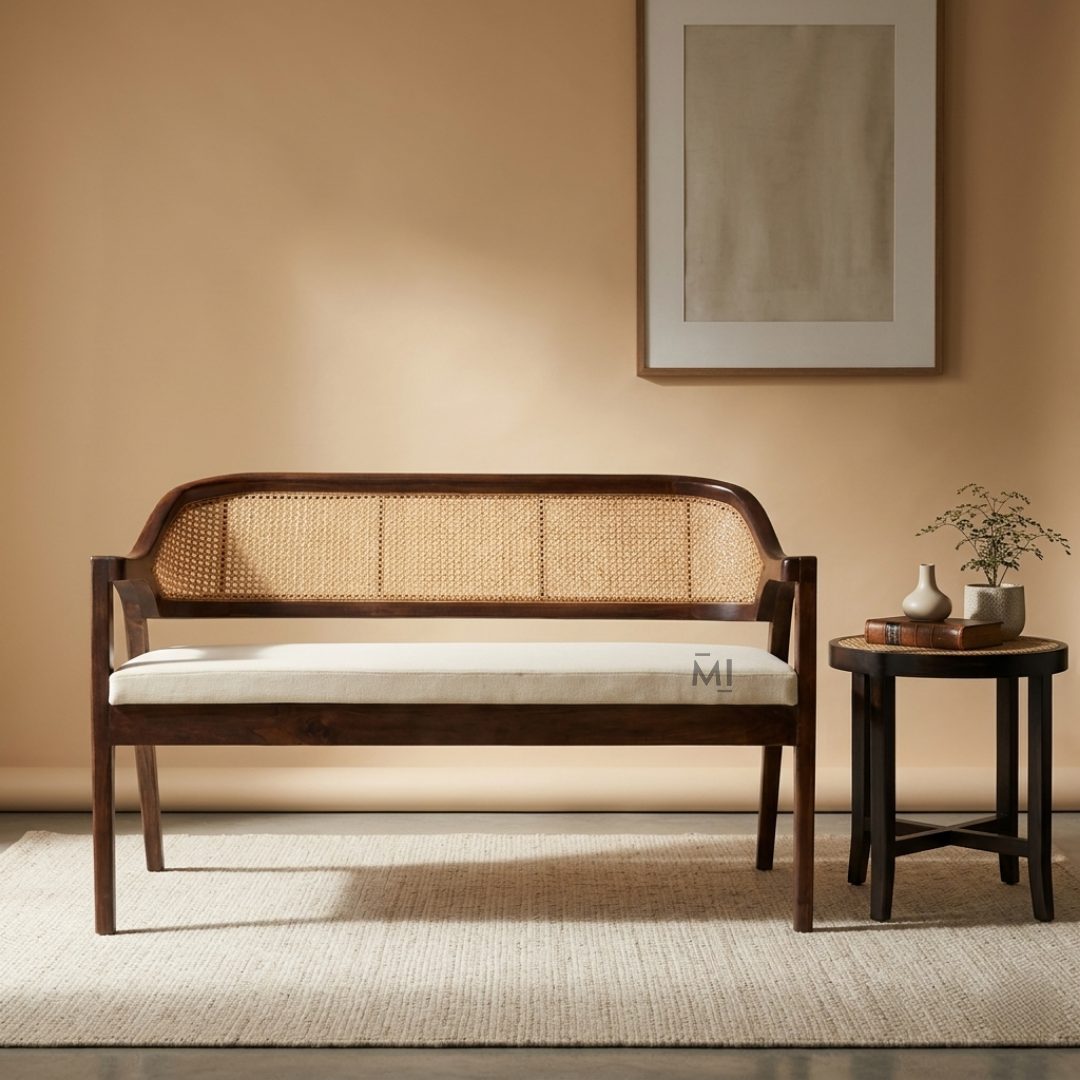 Wooden bench with woven backrest in a room with a beige wall and small table.