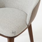 Close-up of a chair with textured gray cushion and wooden legs on a white background