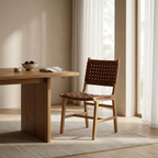 Wooden dining table with a chair in a bright room with large windows.