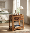 Modern solid wood bedside table with geometric drawer design and open shelf storage beside a contemporary bed